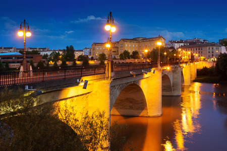 Old bridge (Puente da Piedra) over Ebro river in night. Logrono, Spainの写真素材
