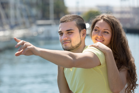 Playful young girl and her boyfriend smiling against seaの写真素材
