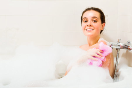 Smiling girl relaxing with foam in bath