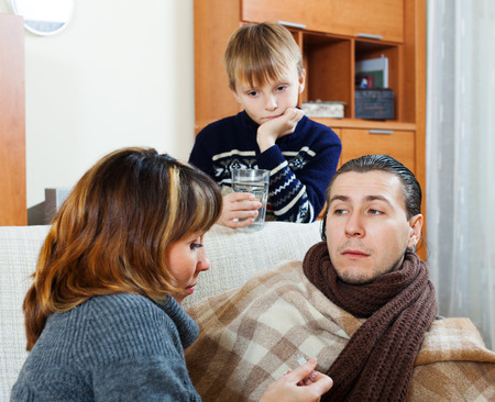 Ailing man surrounded by caring family  at home. Focus on manの写真素材