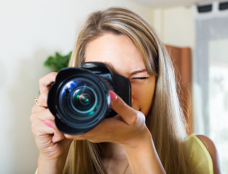 Young smiling girl working with professional photocameraの写真素材