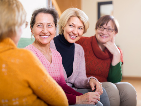 Portrait of senior women having discussion indoor and laughing. Focus on oneの写真素材