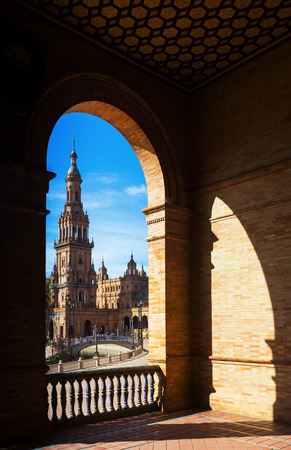 View through the arch of gallery to tower of Plaza de Espana. Seville, Spainの写真素材