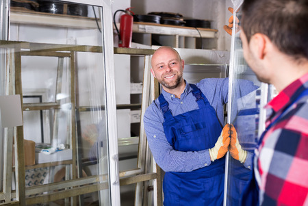 Two  workers inspecting windows at workshopの写真素材