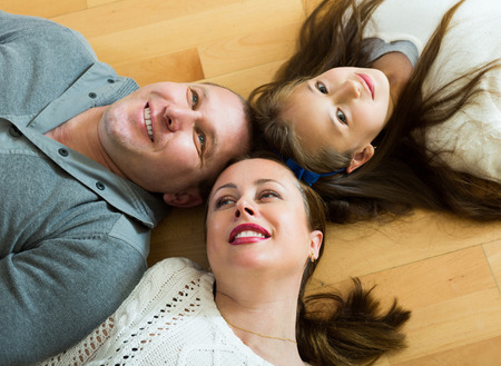 Portrait of mother,smiling father and cute girl together indoorsの写真素材