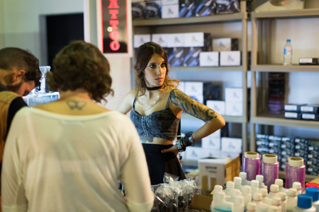 BARCELONA, SPAIN - OCTOBER 3, 2014: Many tubes of  tattoo paint at showcase and artists nearby. The 17th edition of The Barcelona Tattoo Expoのeditorial素材