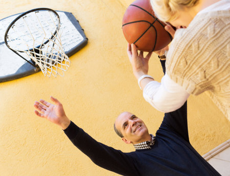 Happy spouses throwing the ball into basket