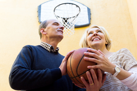 Smiling adult couple playing with ball in yardの写真素材