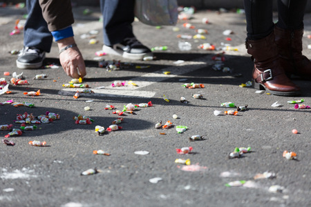 BARCELONA, SPAIN - MARCH 3, 2015: Closeup of people collecting caramels from asphalt. Sant Medir - fiesta, during which participants were given tons of caramelsのeditorial素材