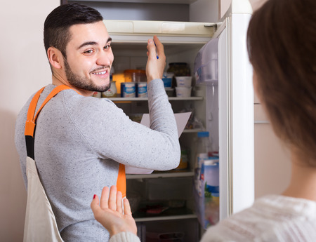 Workman visiting female for after-sales service of refrigeratorの写真素材