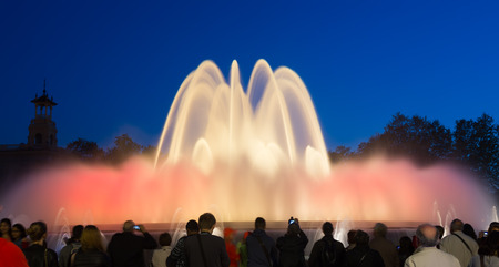 BARCELONA, SPAIN - APRIL 17, 2015: Evening view at colorful vocal fountain Montjuic show and people watching it nearby in Barcelona.  Cataloniaのeditorial素材