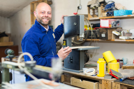 Carpenter cutting a wooden workpiece on an electical jigsaw