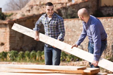 Two farmers working with construction materials outdoorsの写真素材