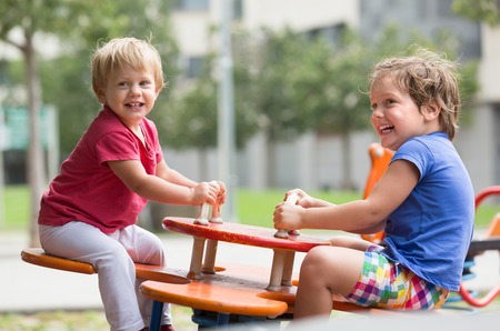 Cheerful little children having fun at city playgroundの写真素材