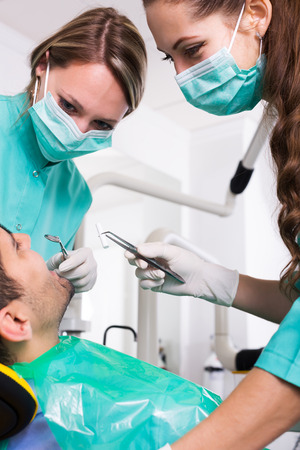 Terrified adult client and dental clinic crew during check upの写真素材