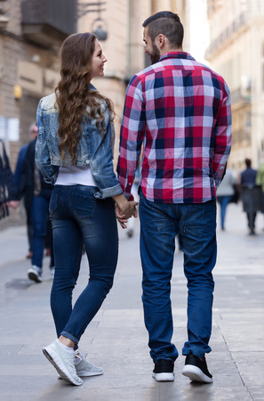 Happy couple walking down the street togetherの写真素材