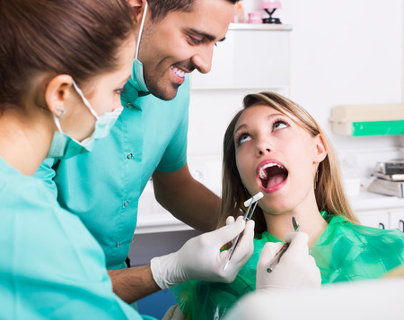 Dentist, assistant and patient at surgery officeの写真素材