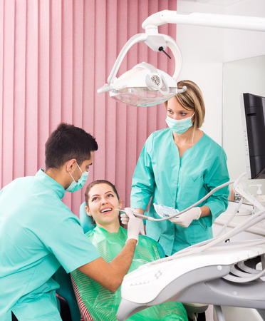 doctor, assistant and young female patient at surgery officeの写真素材