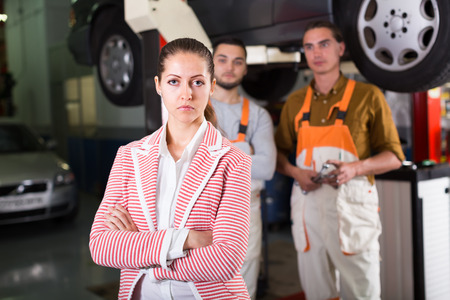 Tired unhappy female client duping by troubleshooters at auto service centerの写真素材