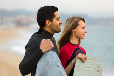 Portrait of young couple on the beach with surf boards. Focus on manの写真素材