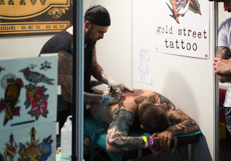 BARCELONA, SPAIN - OCTOBER 3, 2014: Professional artist  doing   tattoo on male client behind. The 17th edition of  Barcelona Tattoo Expoのeditorial素材