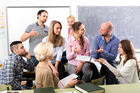 Teacher having informal discussion with his graduate students during a break between subjectsの写真素材