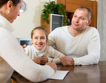 Father and daughter complete a questionnaire for the social workerの写真素材