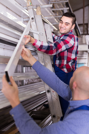 Two workers choosing PVC window profile at standの写真素材