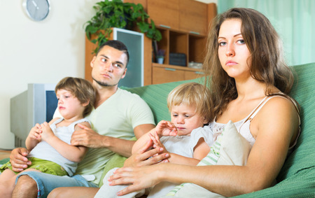 Depressed parents after an argument with children in their armsの写真素材