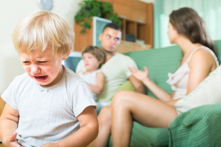 Little child crying due to a quarrel of parentsの写真素材