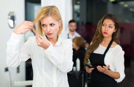 Portrait of discontented young female at the hairdressing salonの写真素材