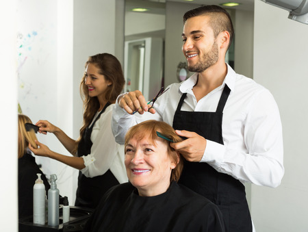 Mature woman cuts hair at the hair salonの写真素材