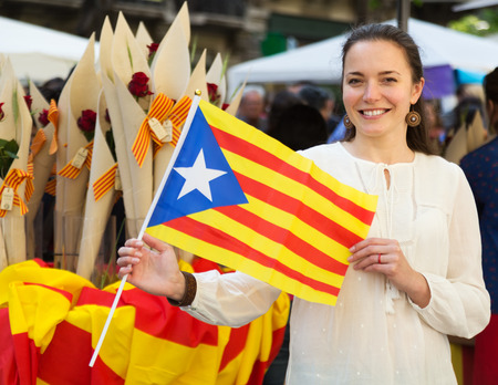 Happy woman with  Flag of Catalonia during Sant Jordi festival in Barcelona, Spainの写真素材