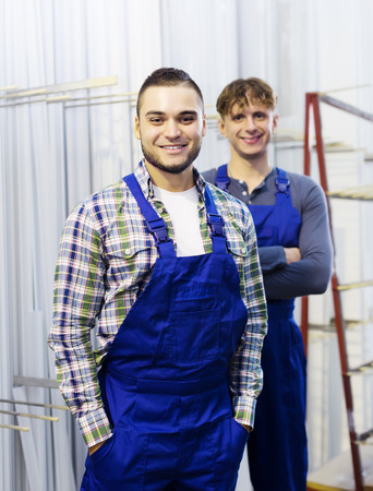 Portrait of production workers in coveralls with window profilesの写真素材