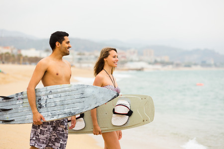 Young surfers couple with surfboards on the beachの写真素材