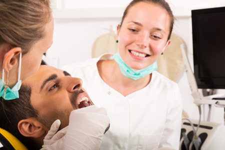 Male patient  treats teeth in the dental clinic. Focus on the patientの写真素材