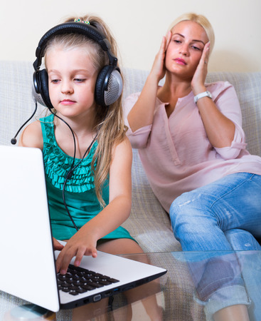 Little girl with internet addiction playing computer game indoorsの写真素材