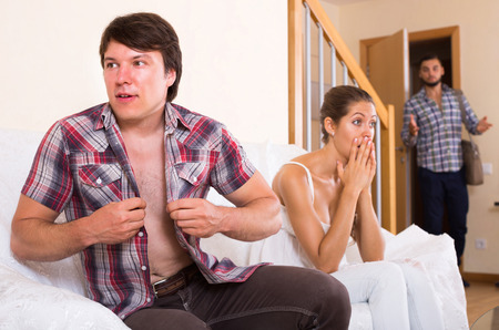 spouse coming home in wrong moment  and having affair with unfaithful womanの写真素材
