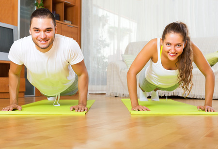 Smiling people doing yoga on mats in roomの写真素材