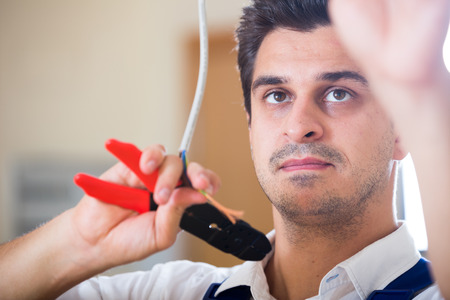 Young professional fixing indoor wiring in new buildingの写真素材