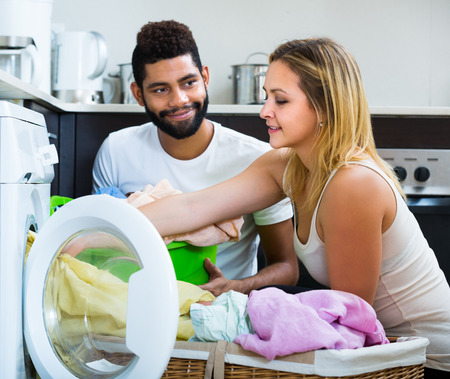 Black man and white girl near washing machineの写真素材