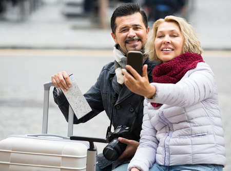 Elderly woman and  man taking selfie on smartphone camera and smilingの写真素材