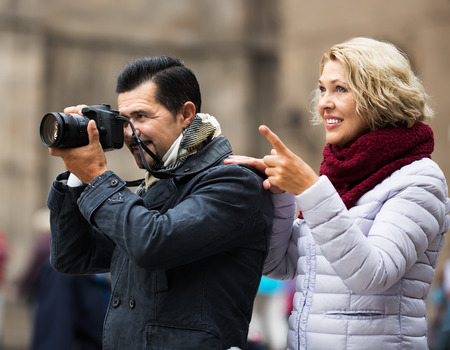 Mature couple of tourists with baggage going to hotelの写真素材
