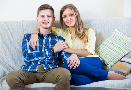 blonde woman and man sitting on couchの写真素材