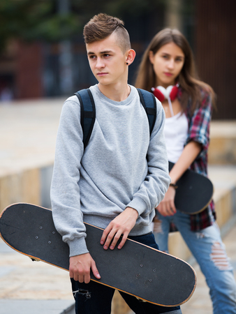 Teenagers with skateboards having a city walk in sunny dayの写真素材