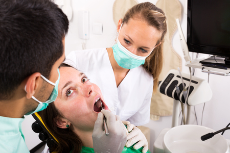 woman patient  treats teeth in the dental clinic. Focus on the patientの写真素材