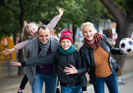 happy american spouses with children posing in autumn park and smilingの写真素材