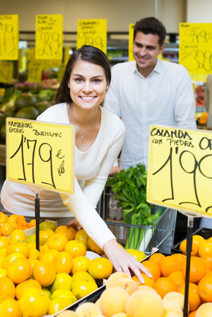 positive european family couple buying fresh seasonal fruits in marketの写真素材