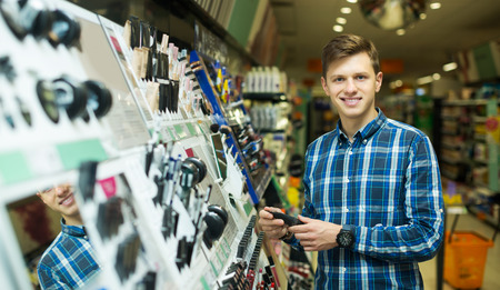 Positive young man chooses beauty treatment for wife in the shopの写真素材