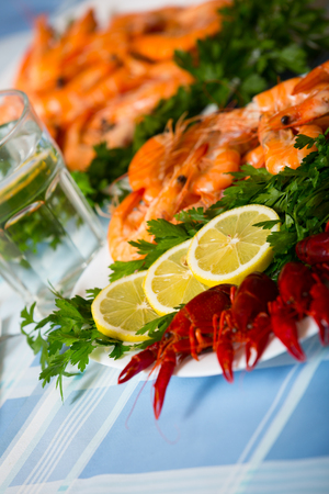 Boiled shrimps and crayfish served with parsley and lemon slicesの写真素材
